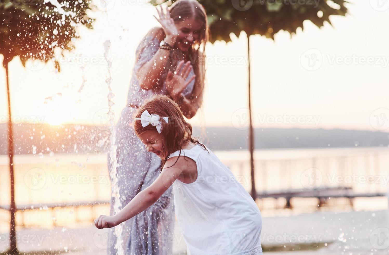 ça continue d'arriver. par une chaude journée ensoleillée, la mère et sa fille décident d'utiliser une fontaine pour se rafraîchir et s'amuser avec photo