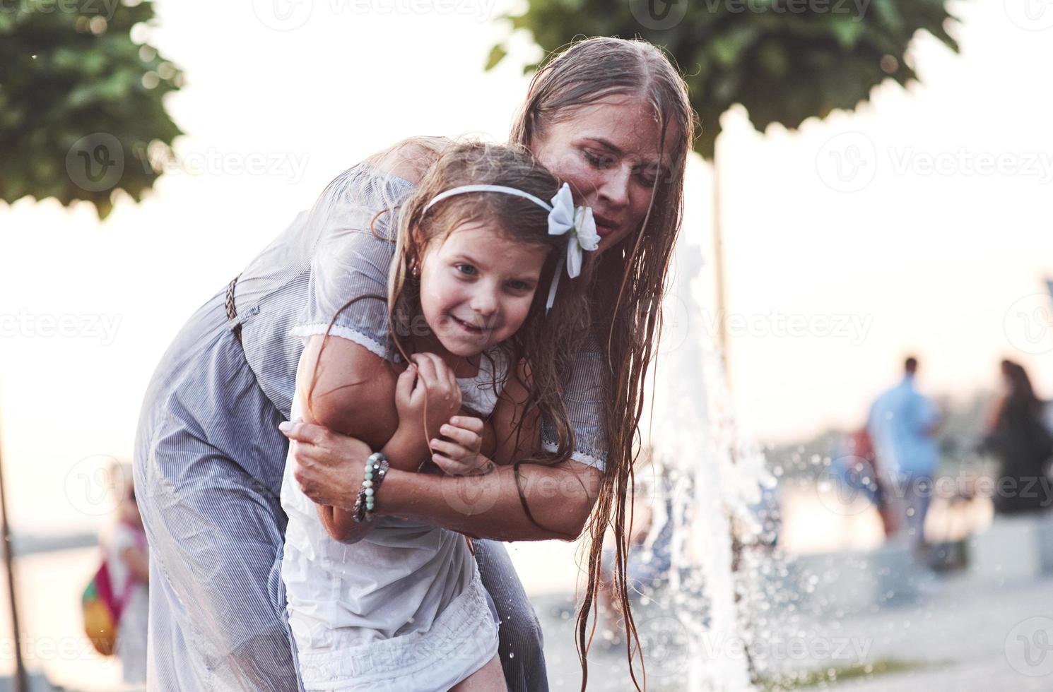 temps pour le reste. par une chaude journée ensoleillée, la mère et sa fille décident d'utiliser une fontaine pour se rafraîchir et s'amuser avec photo