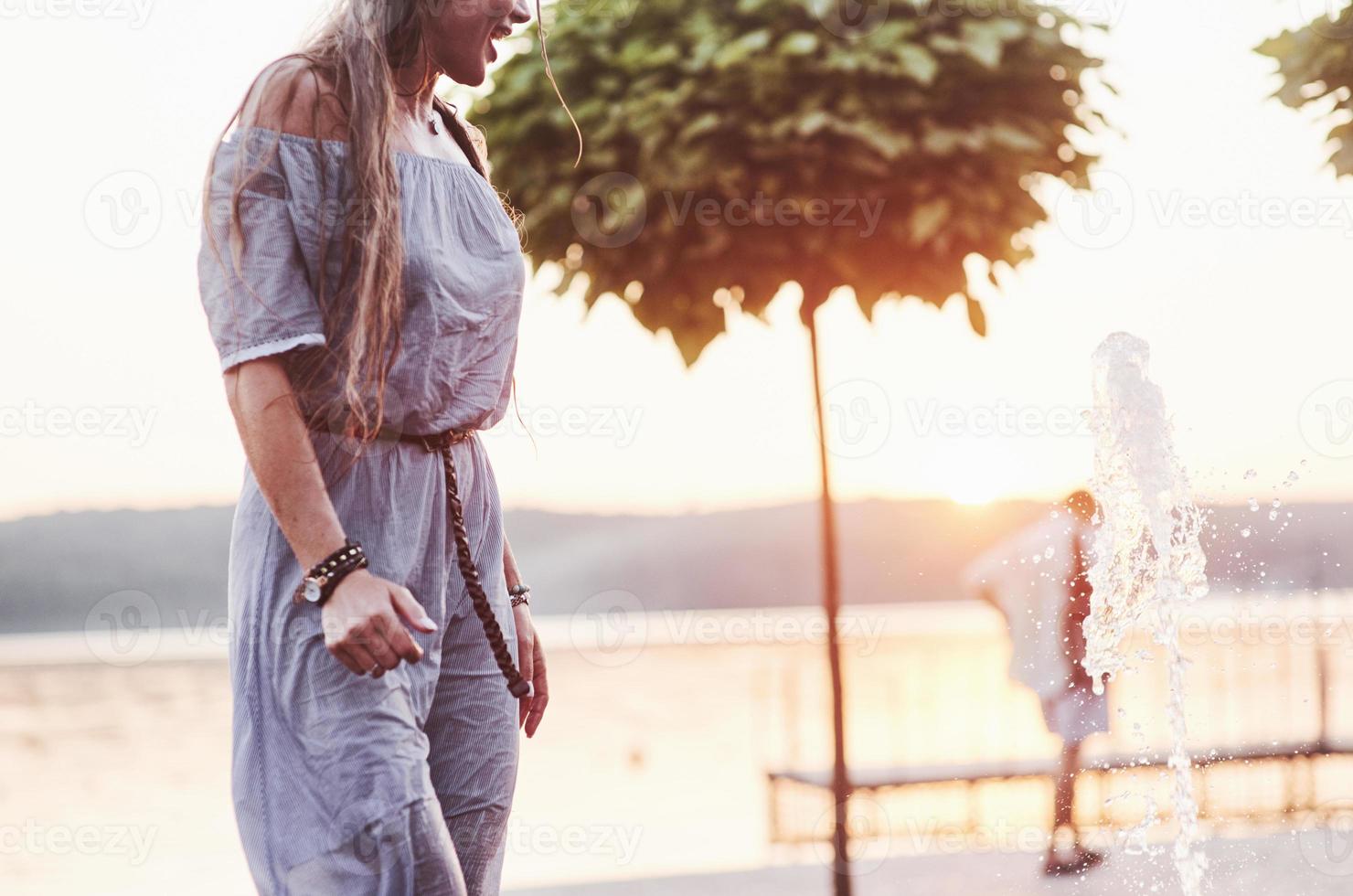 femme adulte humide appréciant le refroidissement au bord de l'eau à une journée chaude photo