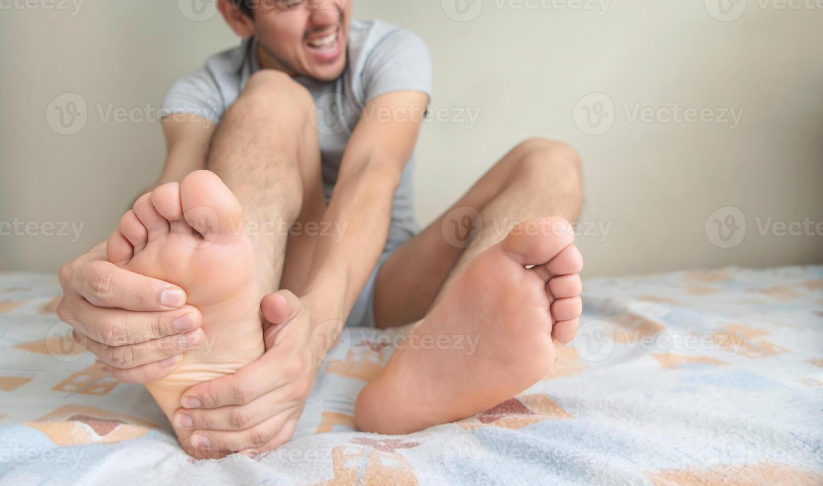 homme en portant le cambre de le pied, avec gestes de Souffrance douleur dans les pièces de le pieds. photo