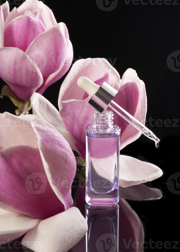 une bouteille de parfum avec une rose fleur dans le noir Contexte photo