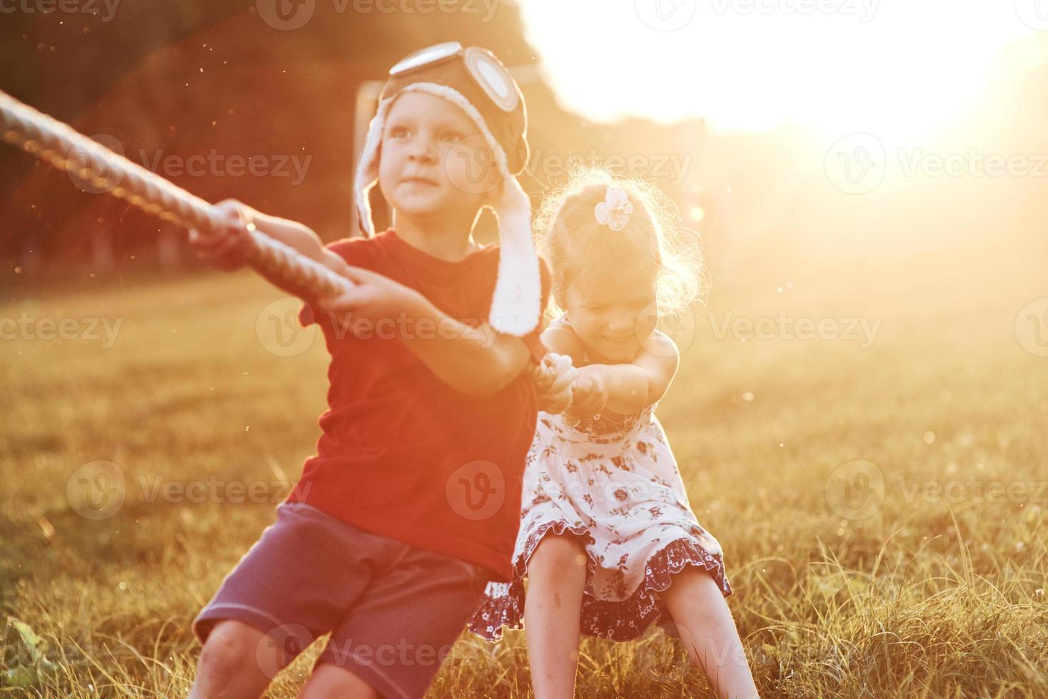 lutter. n'abandonne pas. c'est un tir à la corde avec papa sur une belle herbe d'une journée chaude et ensoleillée photo