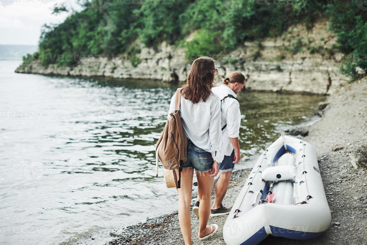 il est temps d'y aller. touristes satisfaits du voyage qu'ils font sur le fond des arbres près du bateau photo