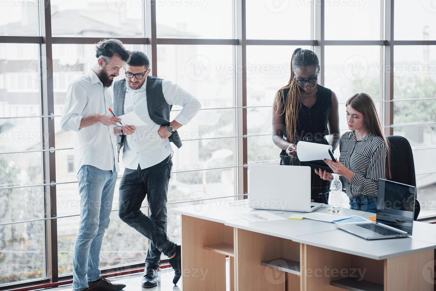 les jeunes gens d'affaires discutent ensemble de nouvelles idées créatives lors d'une réunion au bureau photo