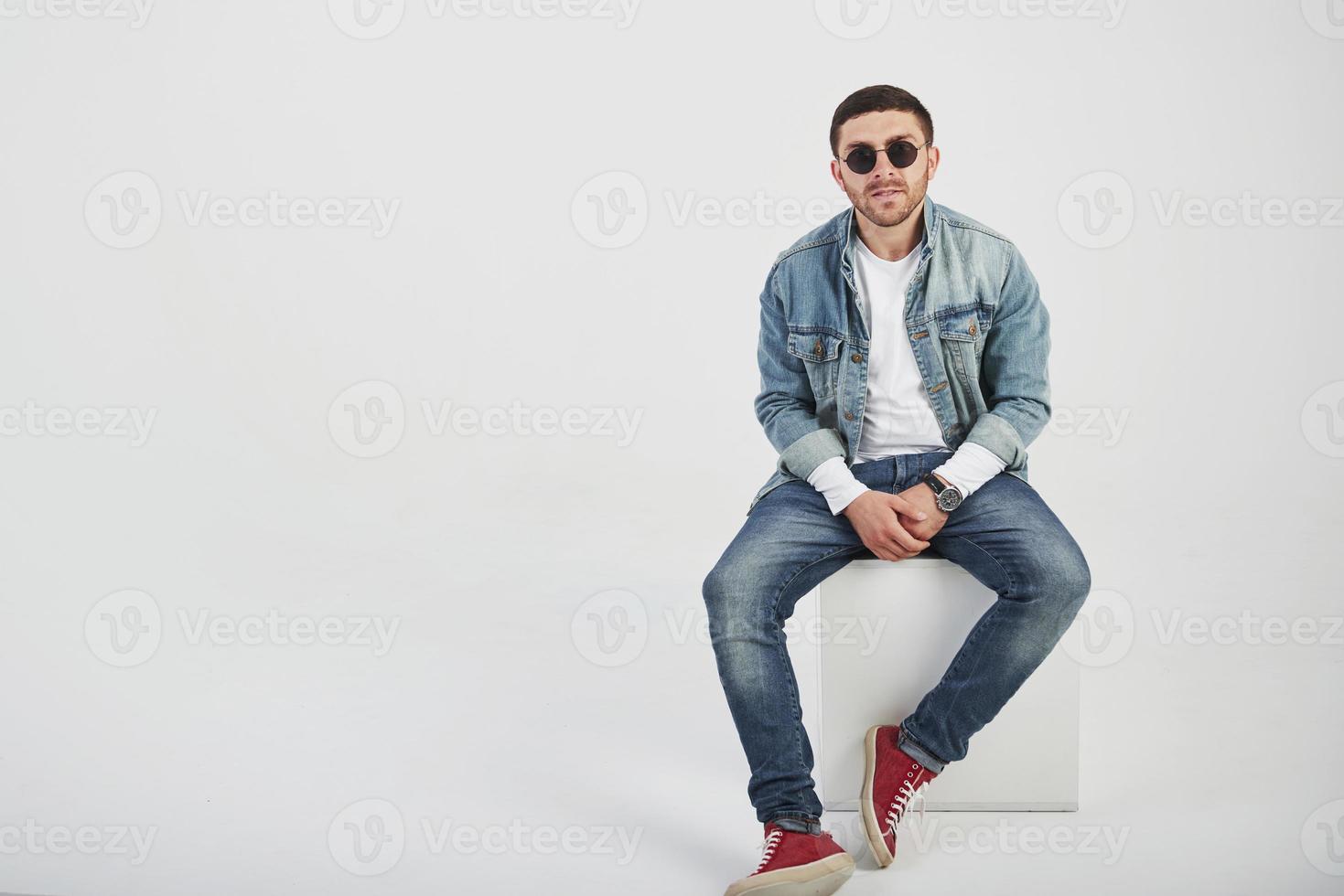 Jeune homme hipster portant des lunettes en riant joyeusement isolé sur fond blanc photo
