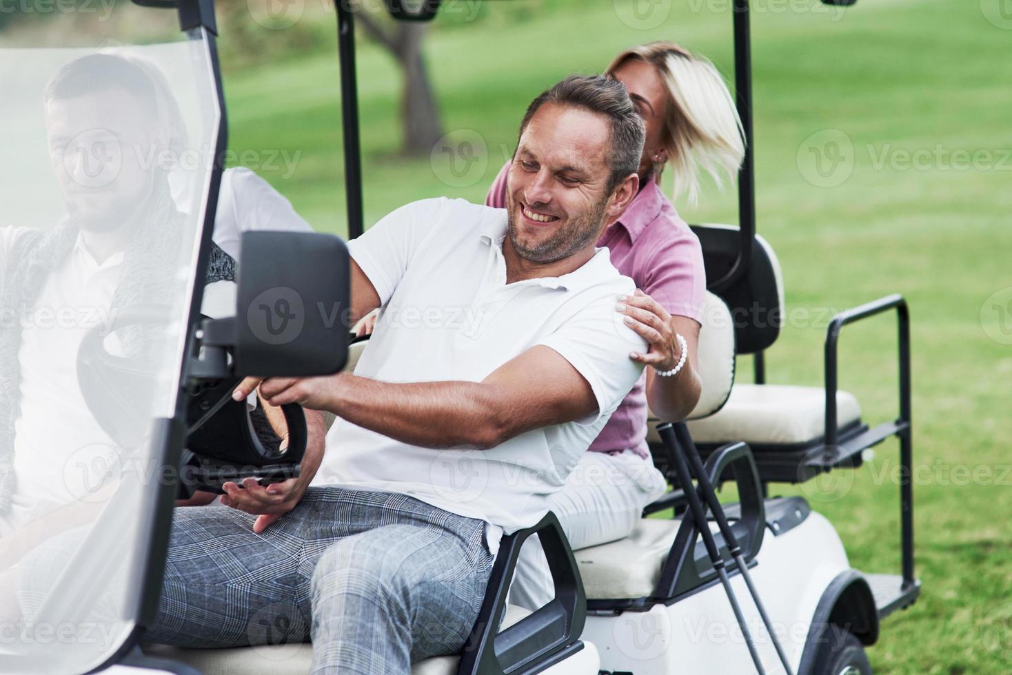 amis de la famille s'amusant sur la voiturette de golf sur le terrain après le match photo