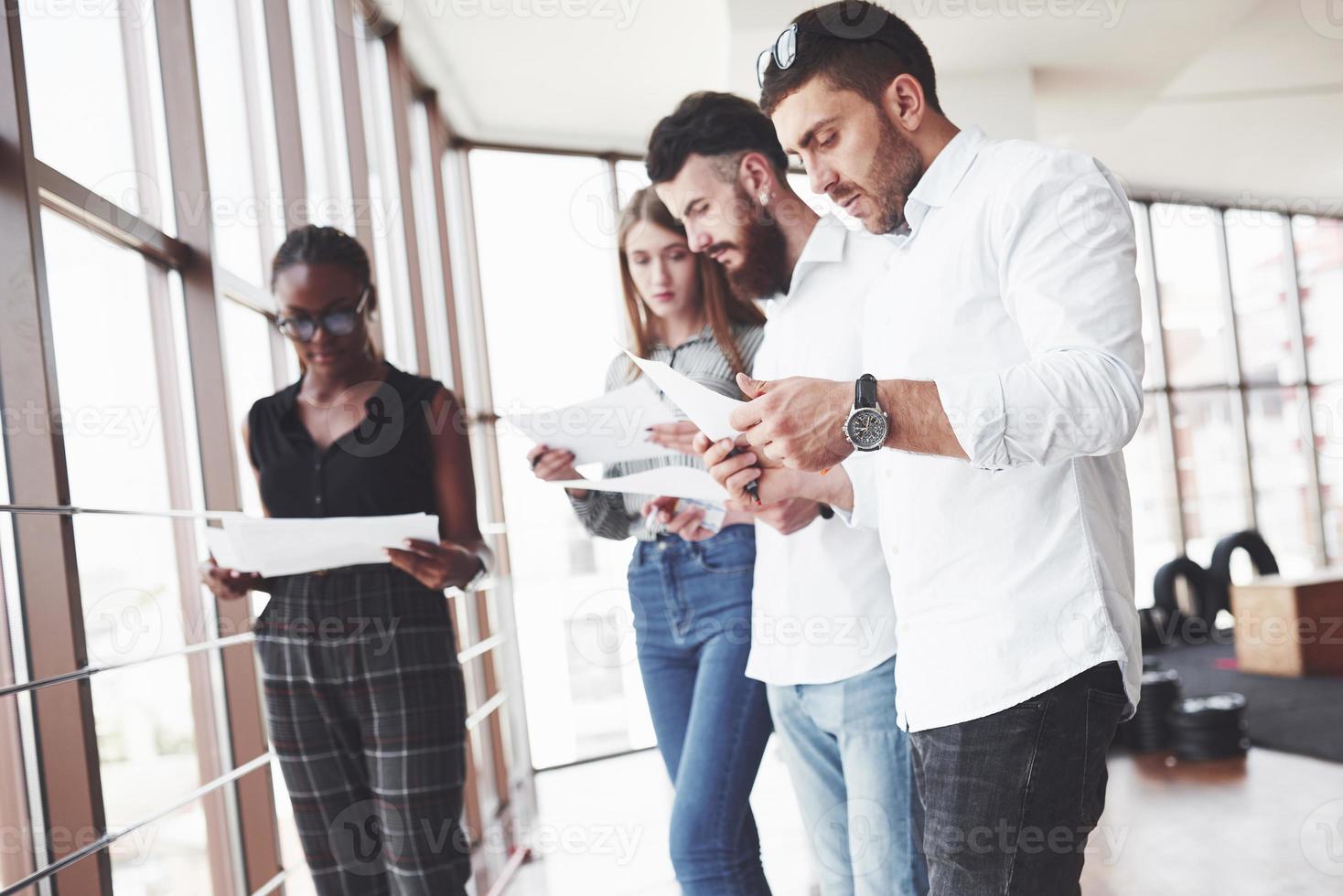 personnes lisant des documents au bureau avec de grandes fenêtres photo