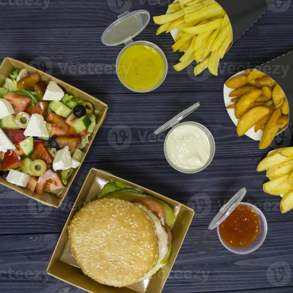Burger salade et français frites avec sauces sur le tableau. photo