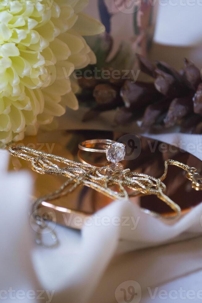 le d'or chaîne et bague avec diamant près fleur, proche en haut. photo
