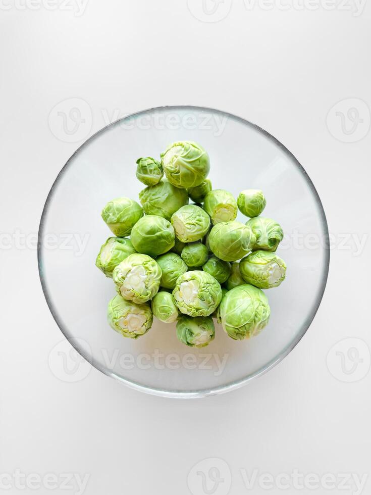 bol de brut Bruxelles choux sur blanc surface. Frais vert légumes, en bonne santé alimentaire, végétarien nourriture concept avec copie espace. photo