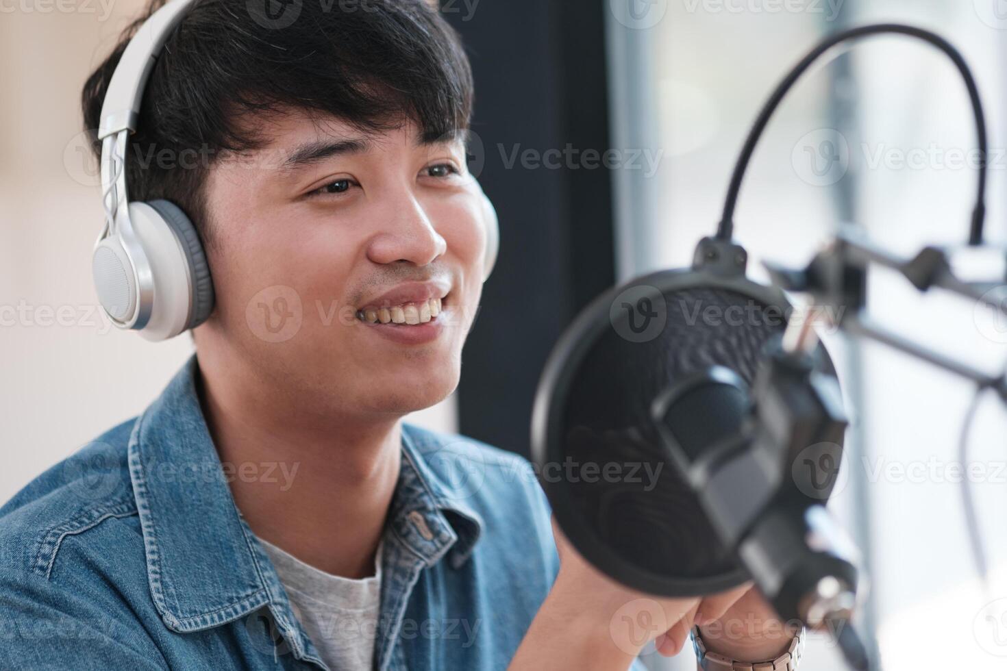 une homme portant écouteurs est souriant tandis que en portant une microphone photo