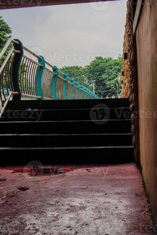 proche vue de le escaliers de premier plan à le jardin avec le clôture partage le rivière. photo