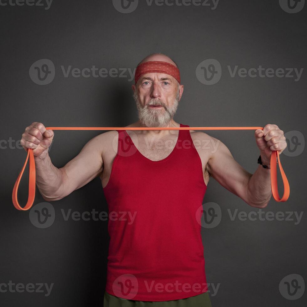 Sénior homme est exercice avec la résistance bande photo