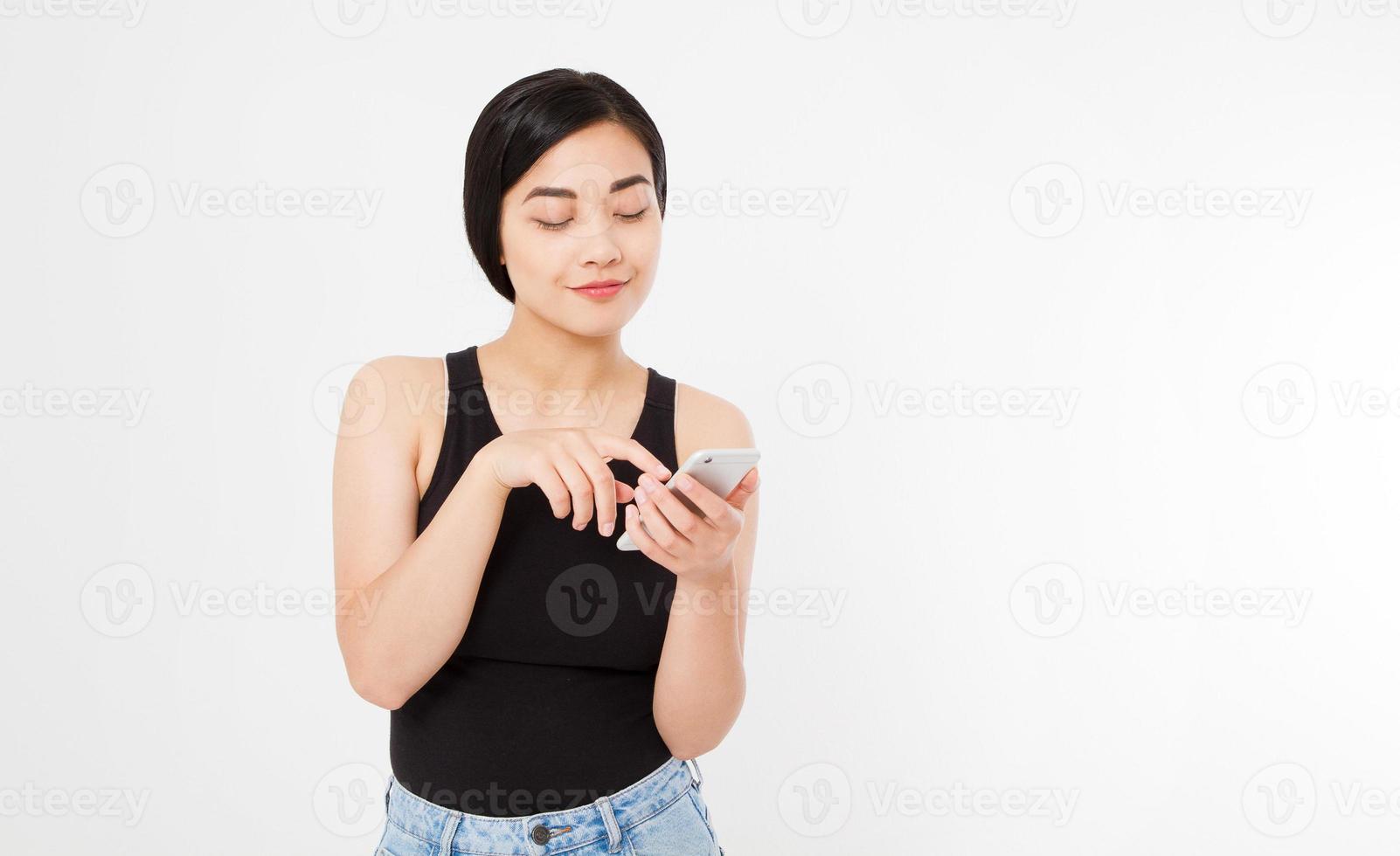 femme textos. gros plan jeune heureuse belle femme japonaise asiatique. fille regardant un téléphone portable isolé sur fond blanc. expression de visage positif émotion humaine. espace de copie. photo