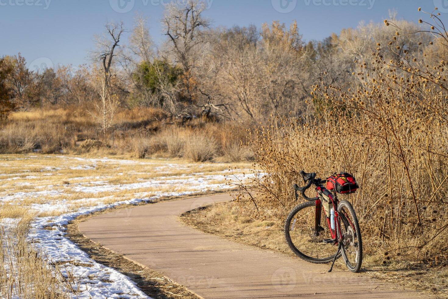 tournée gravier bicyclette à sur une Cyclisme Piste dans fort collins, Colorado dans tomber paysage avec certains neige et séché tournesols photo