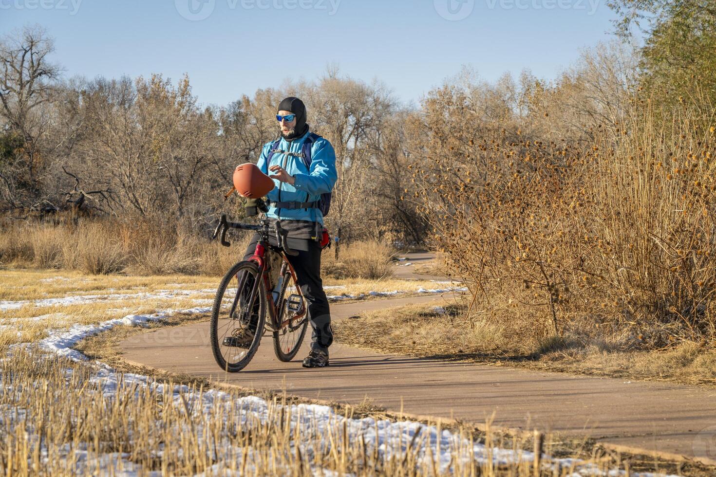 Sénior Masculin cycliste avec une tournée gravier bicyclette sur une Cyclisme Piste dans fort collins, Colorado dans du froid tomber temps avec certains neige photo