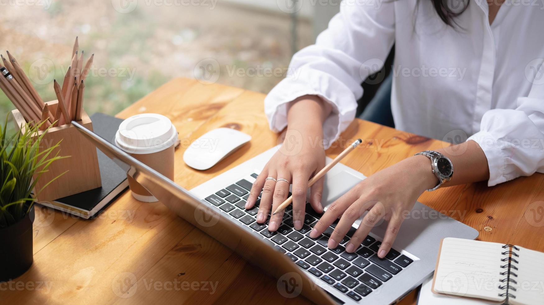 gros plan des mains d'une étudiante comparant des notes sur une tablette numérique assise sur un bureau. femme utilisant une tablette au café. concept de finance d'entreprise. photo