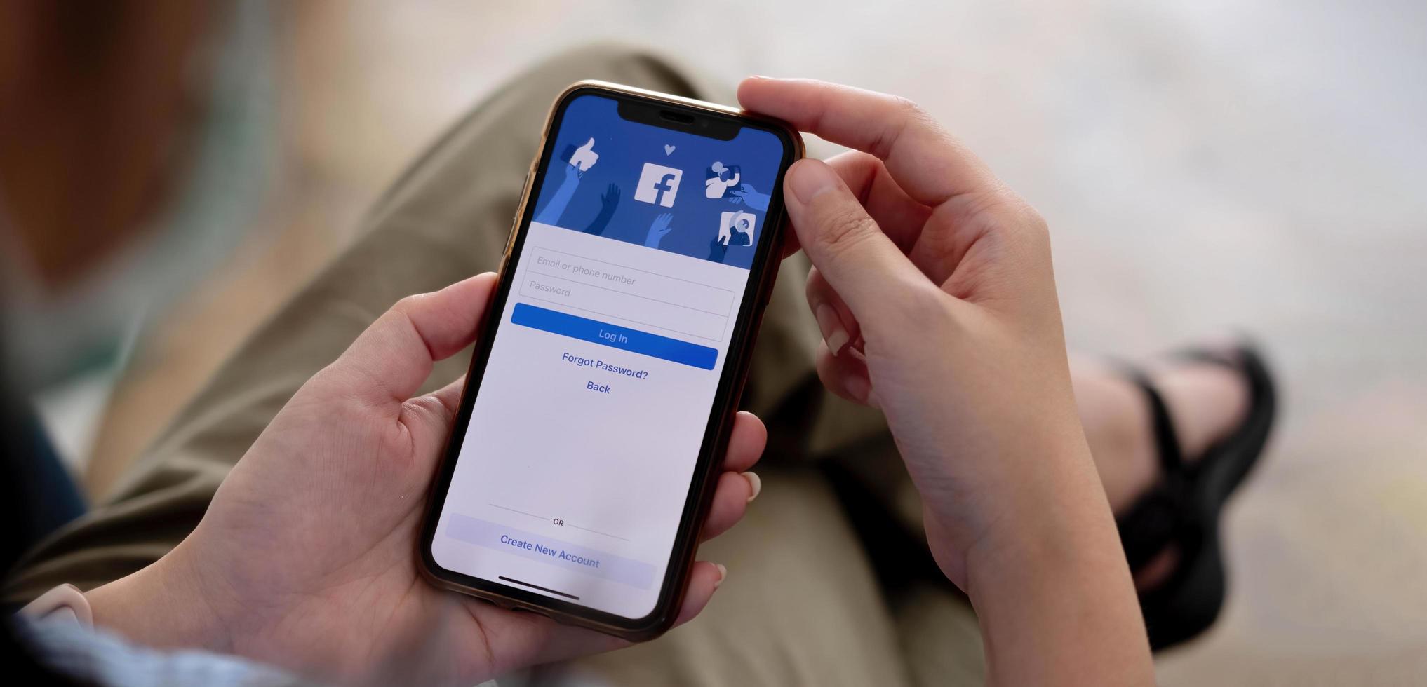femme tenant un iphone x avec le service internet social facebook sur l'écran. photo