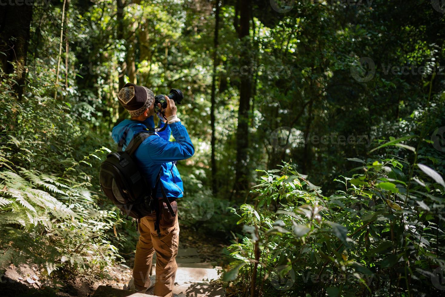 photographe professionnel prend des photos avec appareil photo dans la forêt