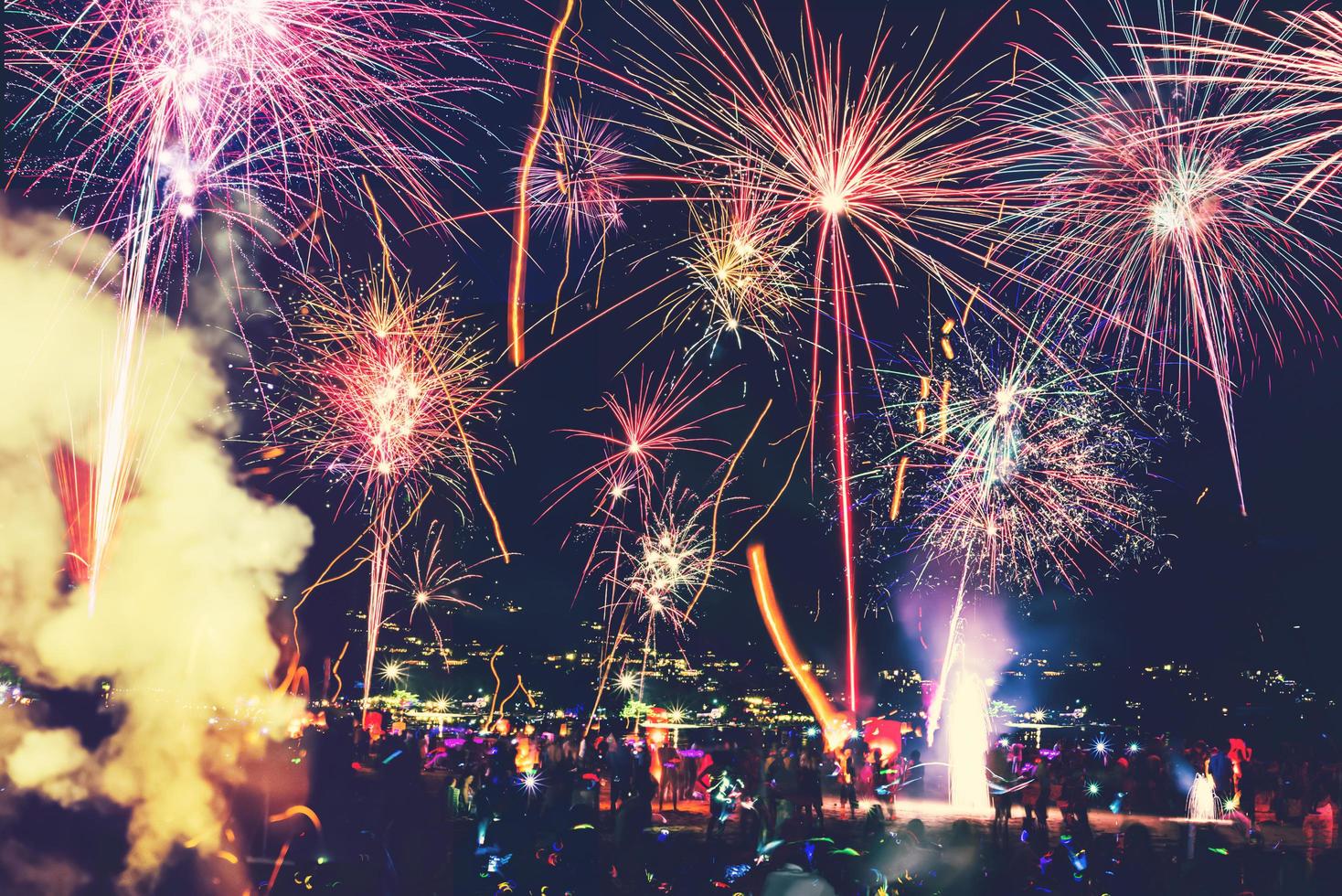 fond nouvel an festif avec feux d'artifice et bokeh. feux d'artifice du nouvel an sur la plage. photo