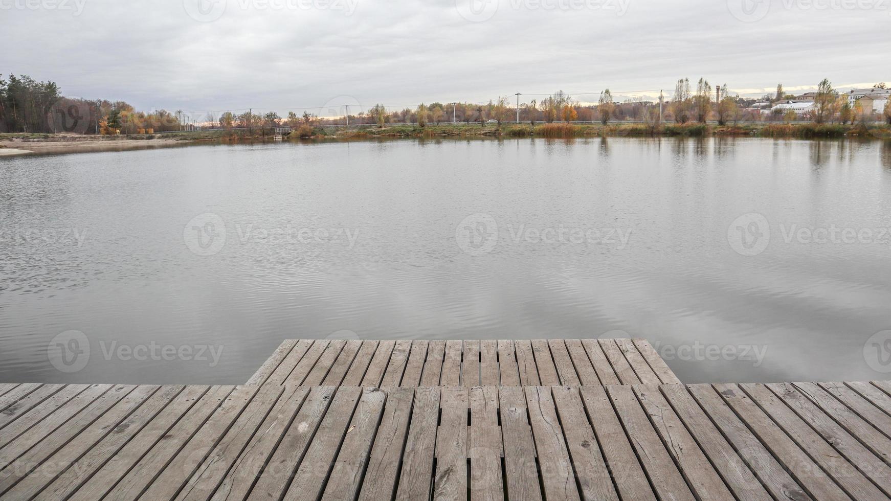 une petite jetée en bois sur un lac tranquille le matin brumeux d'automne. photo