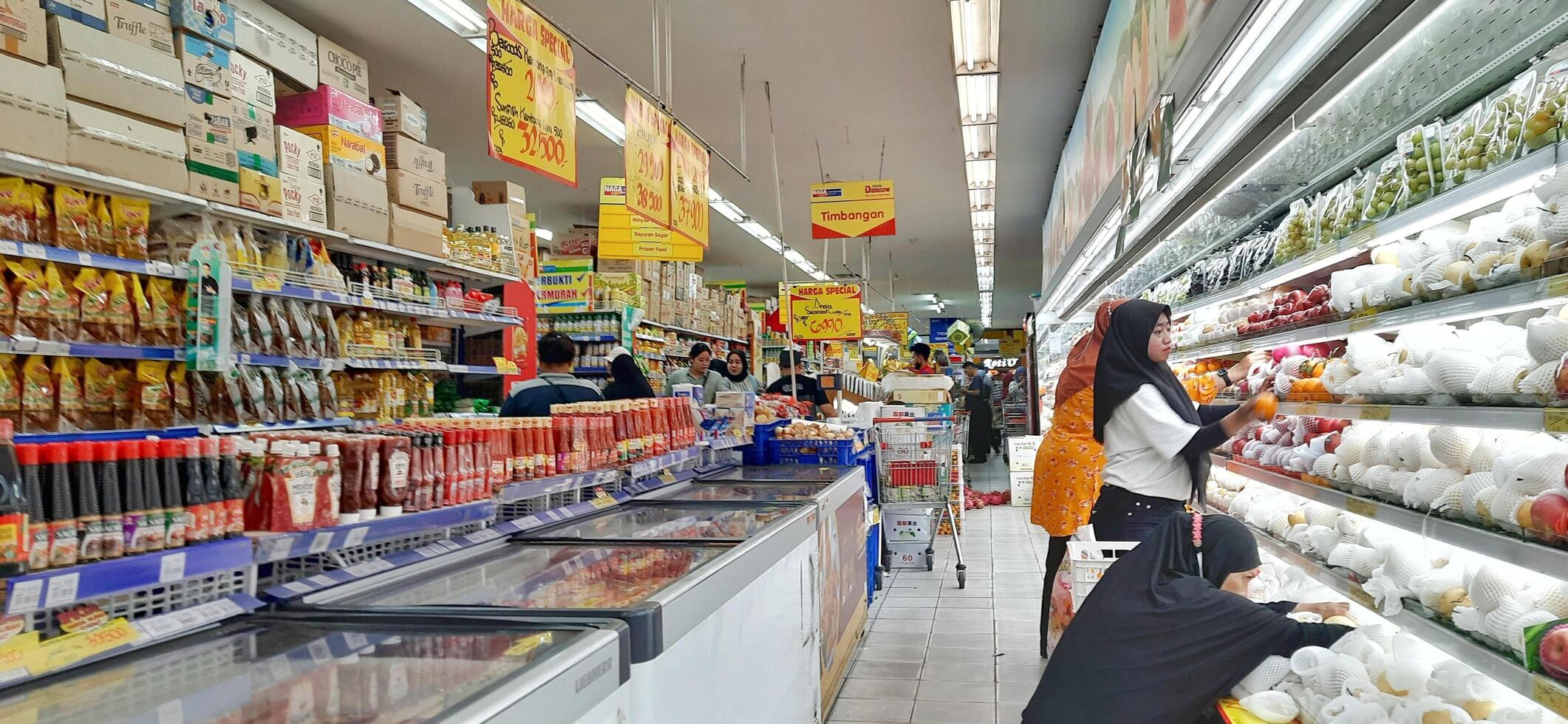 client choisir divers les courses des produits dans épicerie magasin. supermarché concept. bekasi, Ouest Java, Indonésie - Mars 8 2024 photo