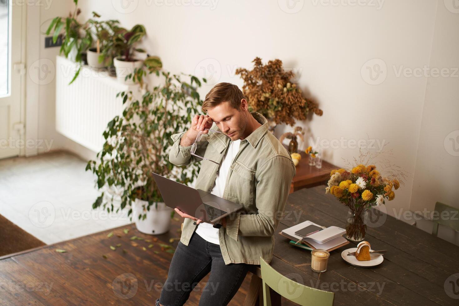 image de Jeune homme, réussi homme d'affaire séance sur tableau, à la recherche à ordinateur portable, travail dans un bureau, à la recherche concentré sur le projet, Faire emploi tâche, en buvant café photo