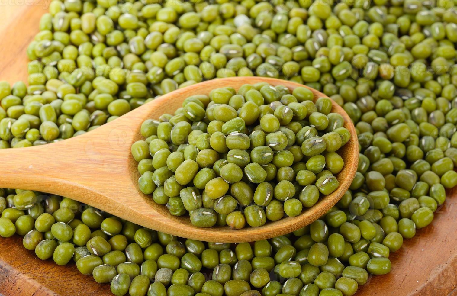 Haricot vert en cuillère de bois sur fond blanc photo