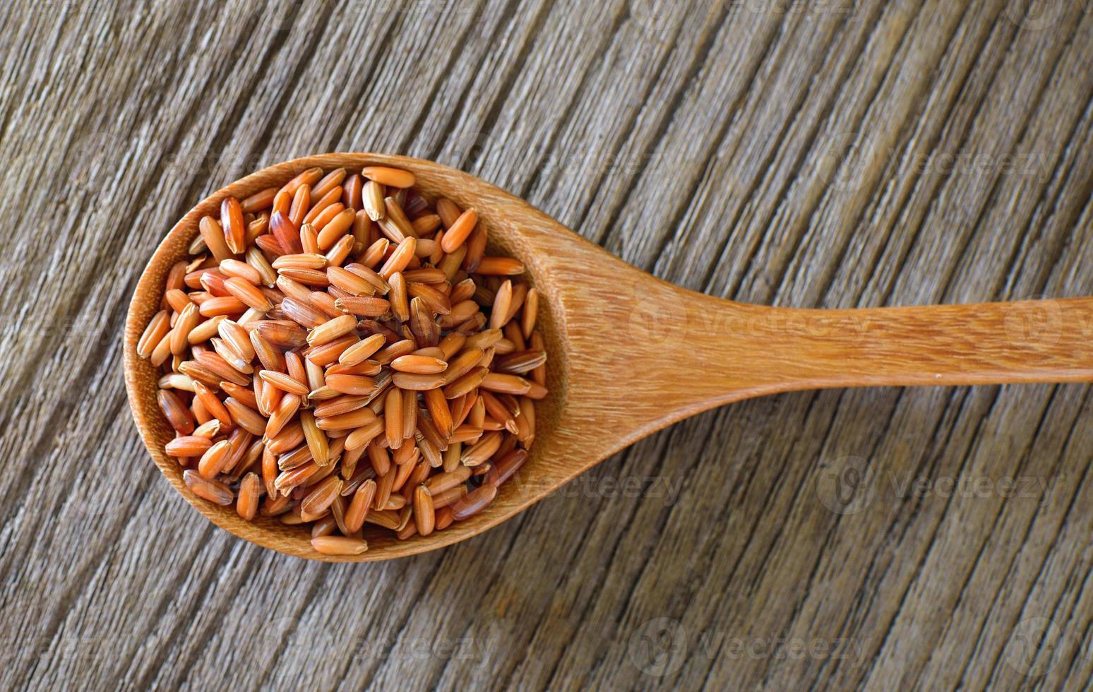 riz brun en cuillère de bois sur table photo