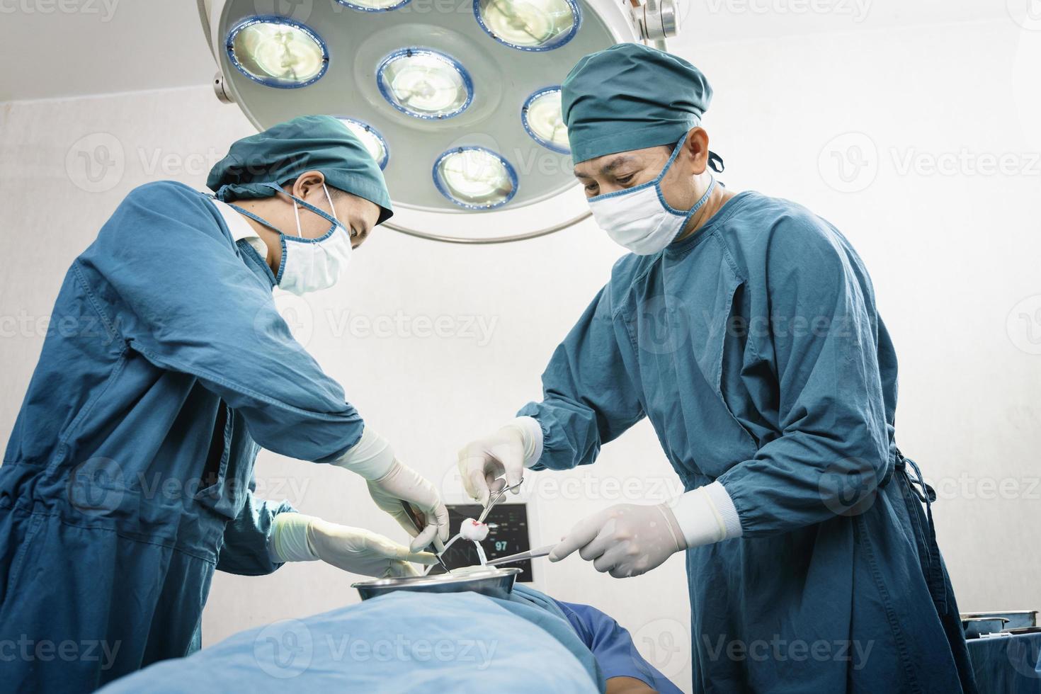 chirurgien opérant un patient avec un assistant dans la salle d'opération. concept de chirurgie et d'urgence photo