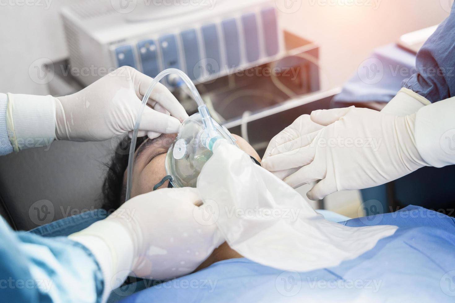 le chirurgien assistant a mis le patient sur un masque de ventilation-oxygène en vue de la chirurgie. photo