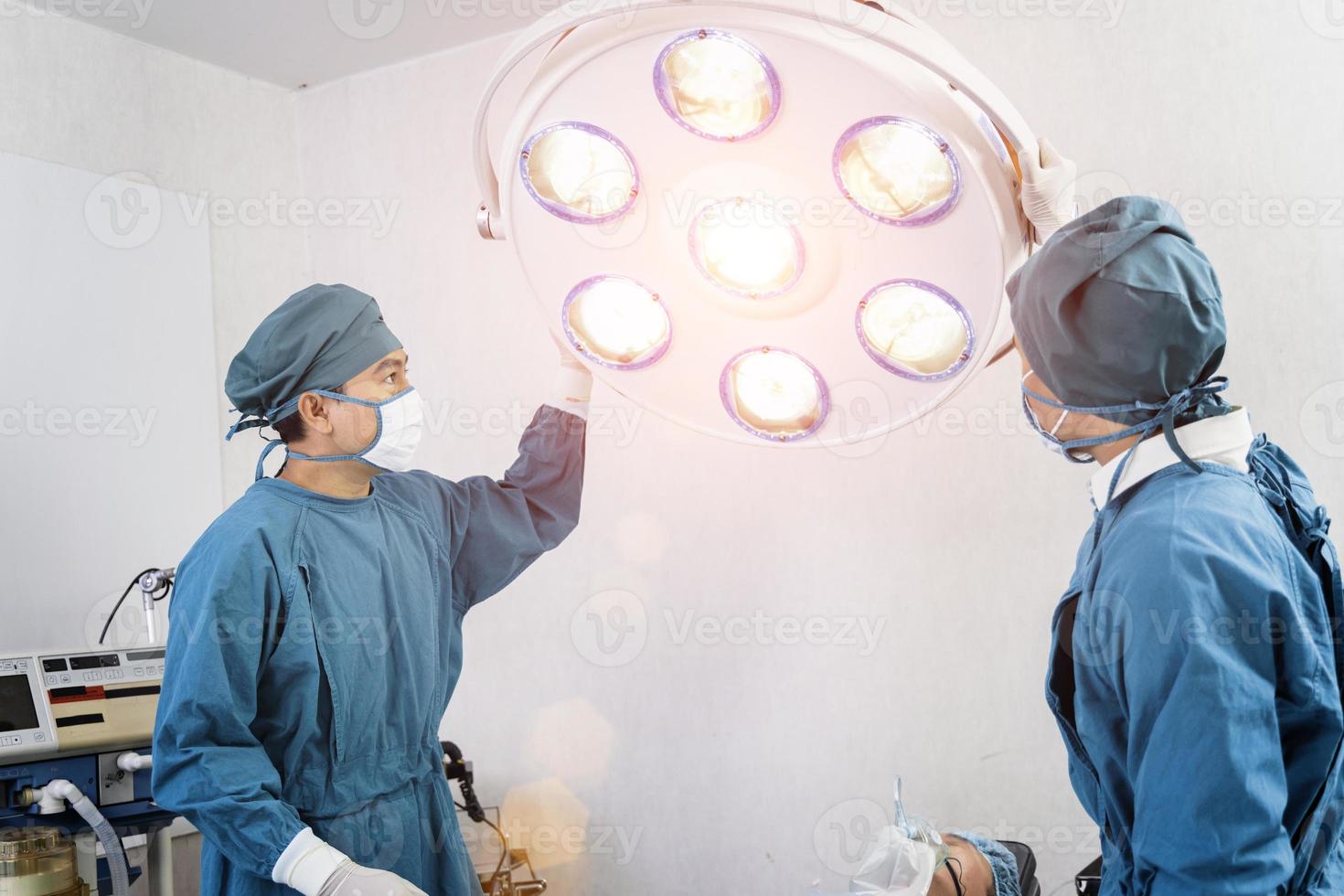 chirurgien assistant préparant des lampes chirurgicales dans la salle d'opération photo