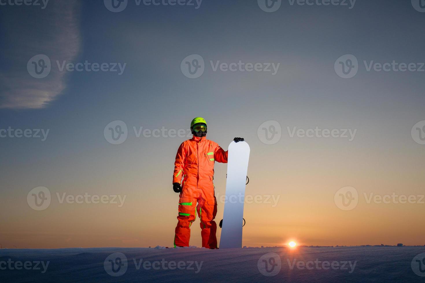 snowboarder au sommet de la piste de ski au fond d'un beau coucher de soleil photo