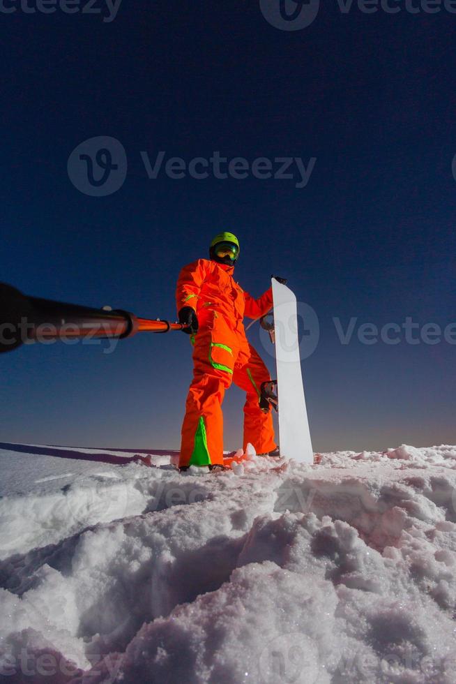 snowboarder faisant un selfie par sa caméra d'action sur le dessus de la piste de ski photo