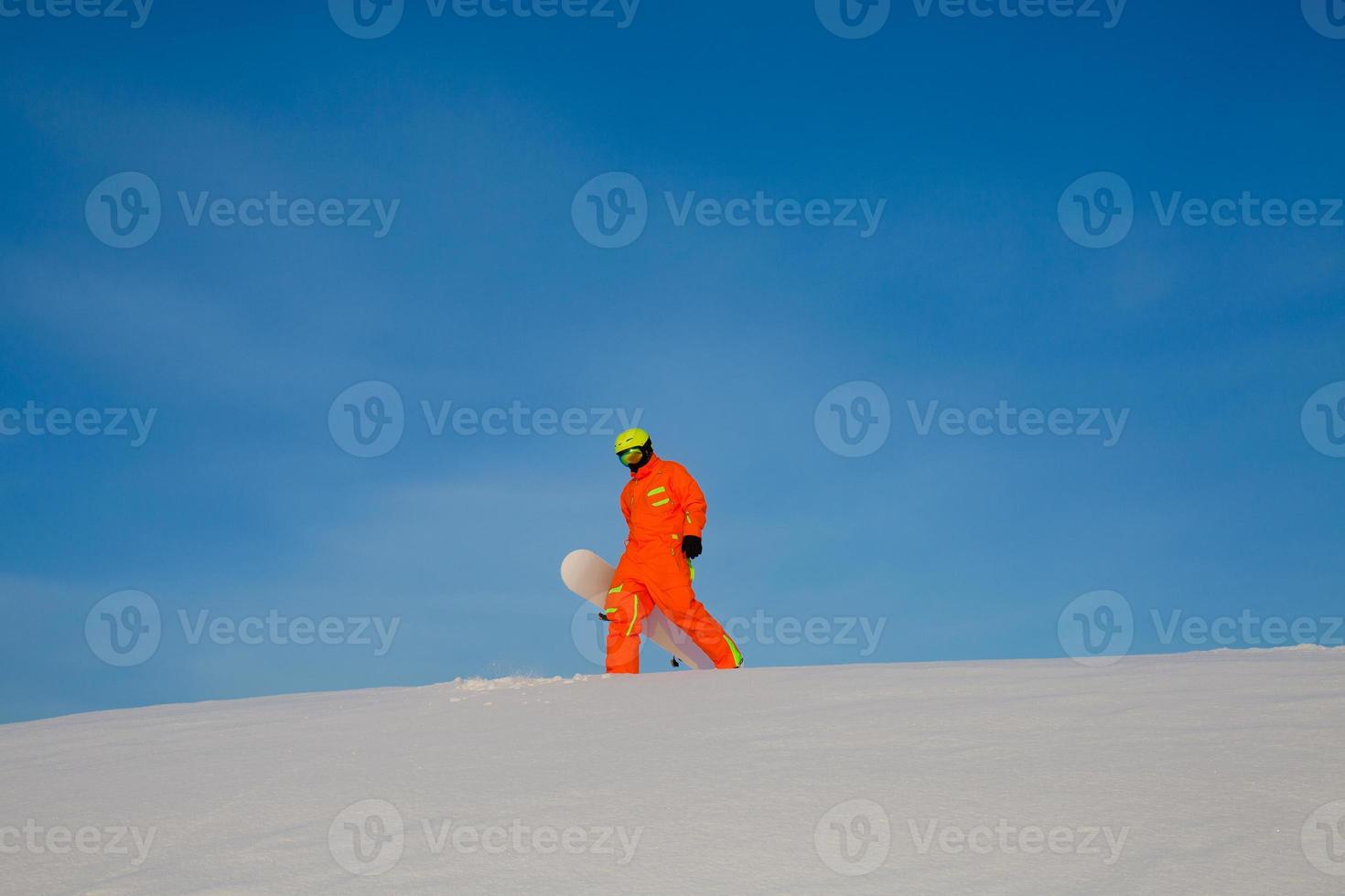 snowboarder freerider avec snowboard blanc debout au sommet de la piste de ski photo