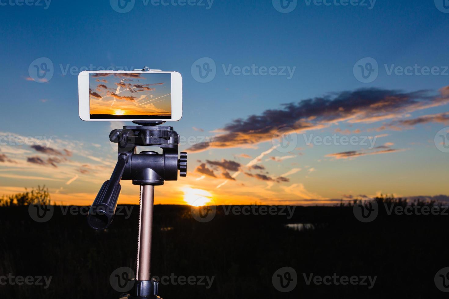smartphone sur trépied capturant l'image d'un magnifique coucher de soleil photo
