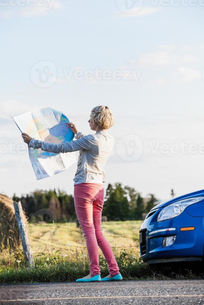 femme pensive sur une scène rurale en regardant une carte photo