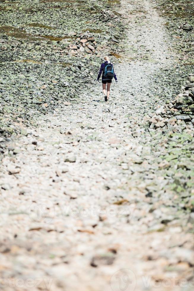 femme marchant sur un chemin de randonnée rocheux photo