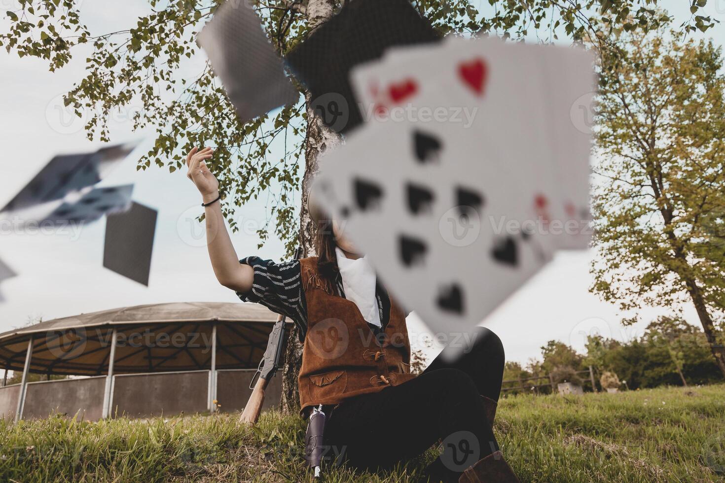 portrait de une magnifique chinois femelle cow-girl en jouant avec poker cartes photo