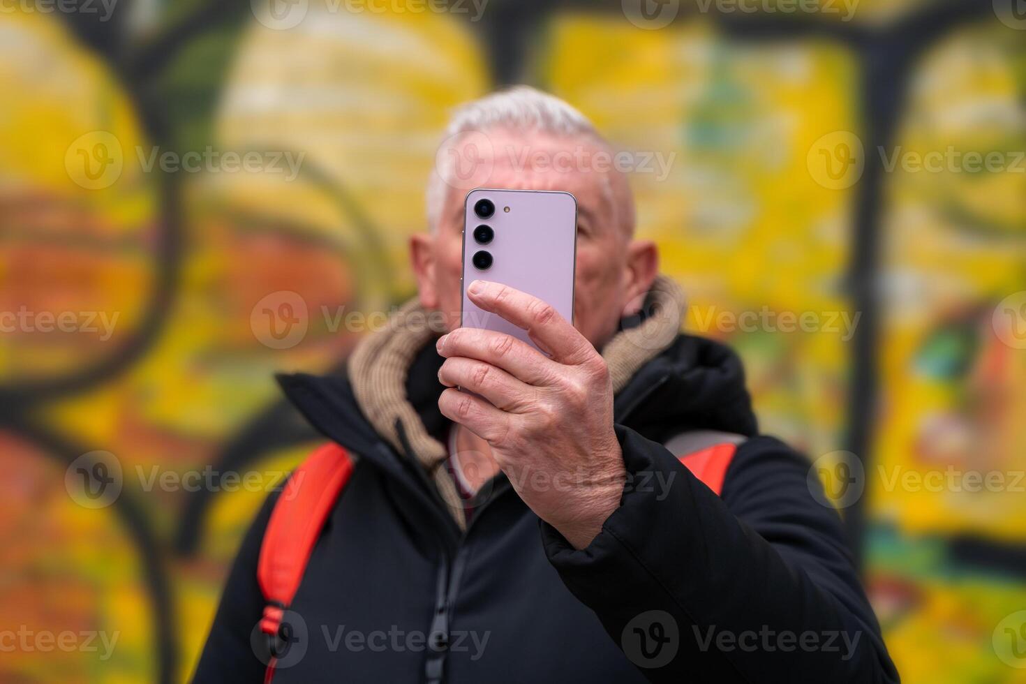 content milieu vieilli homme sur vacances prise une selfie dans de face de défocalisé graffiti dans Rome photo