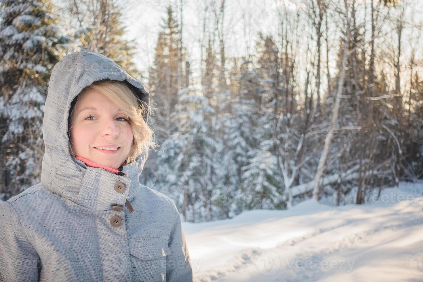 jeune femme heureuse marchant seule dans la forêt pendant l'hiver. photo