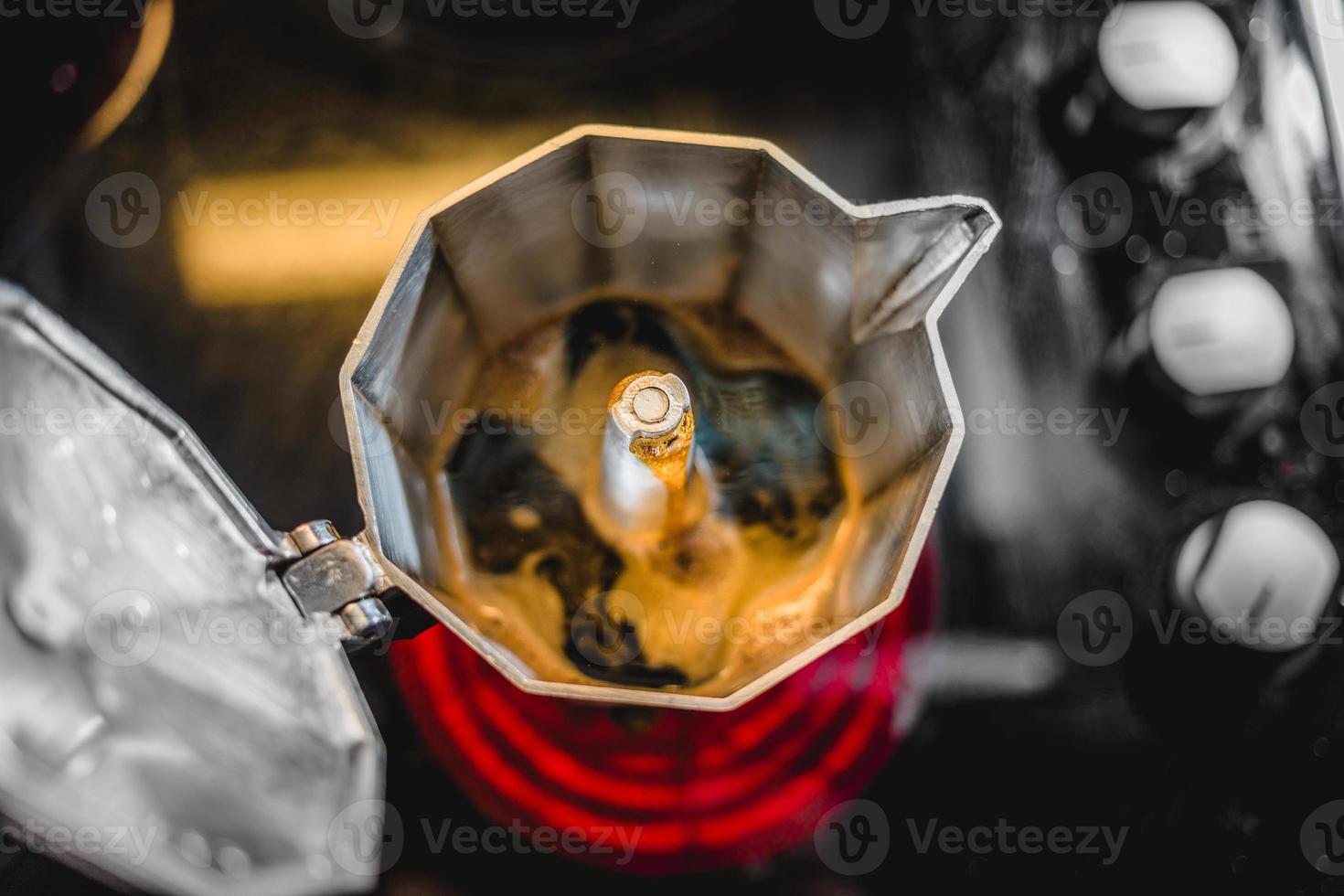 Cafetière italienne en aluminium préparant un café noir frais sur la cuisinière photo