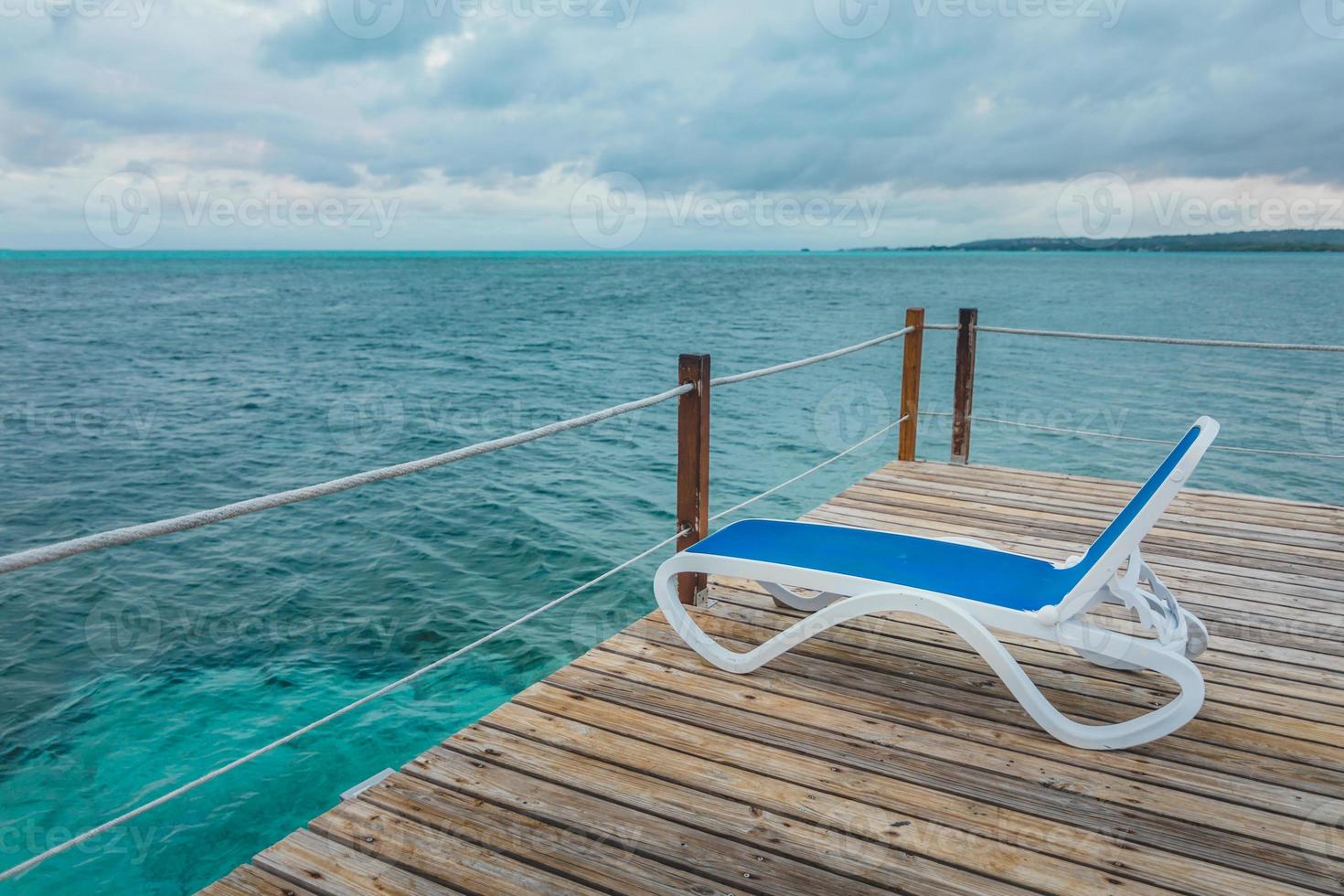 jetée en bois et longues chaises bleues sans personne photo