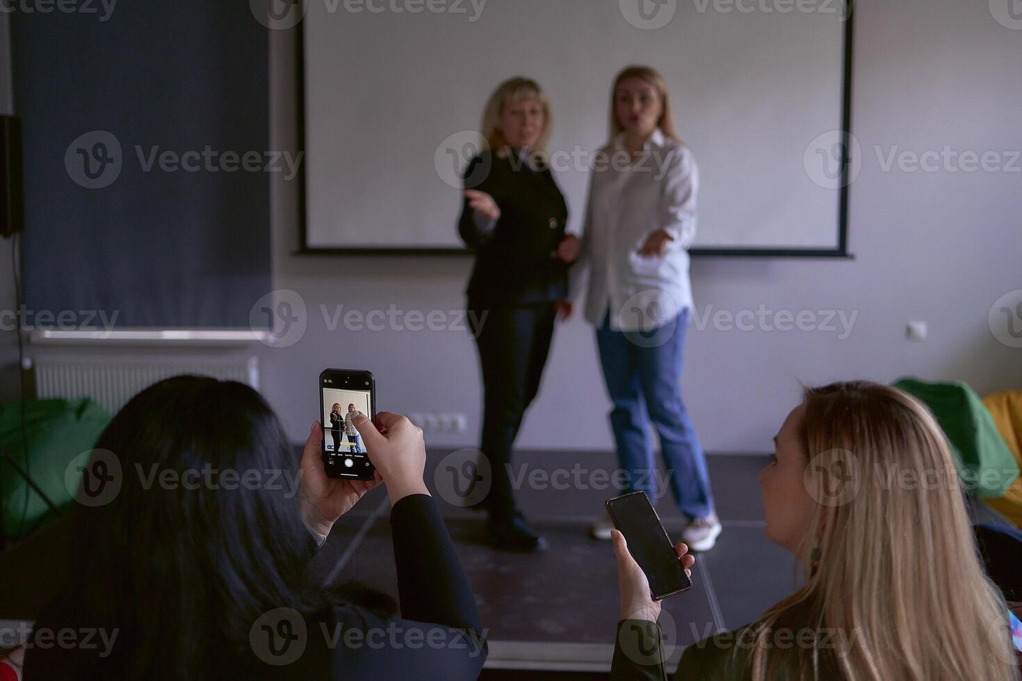 deux milieu âge femmes dans affaires costume sur étape dans le Bureau photo