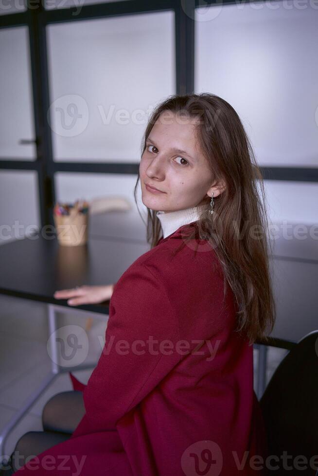 portrait de une Jeune femme dans une rouge Bureau costume photo
