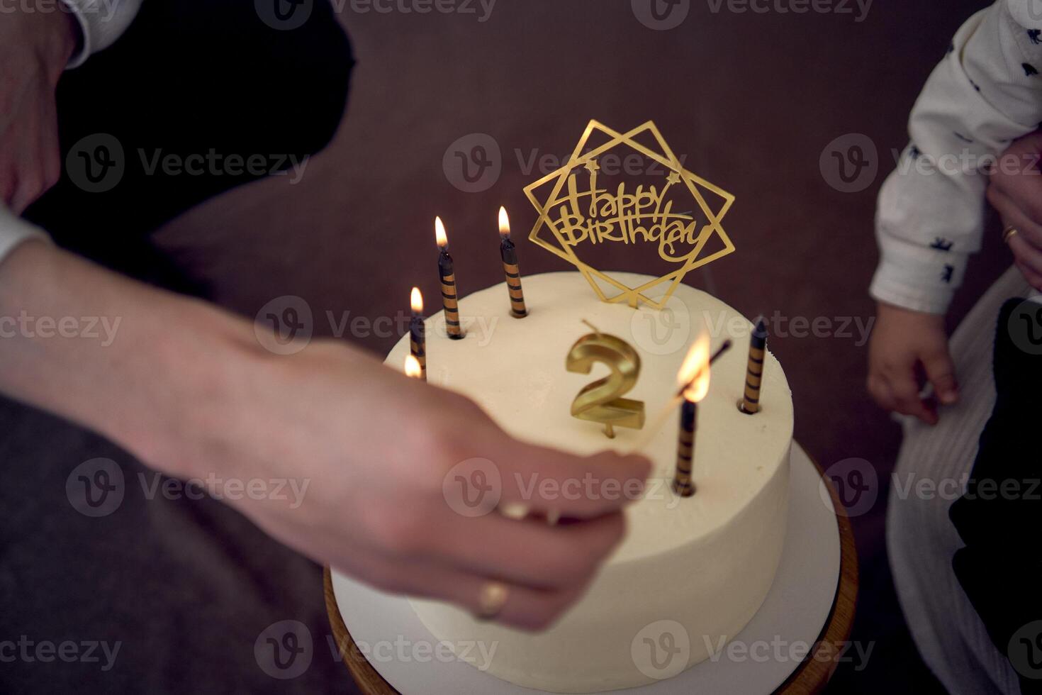 père lumières bougies sur le sien fils seconde anniversaire gâteau photo