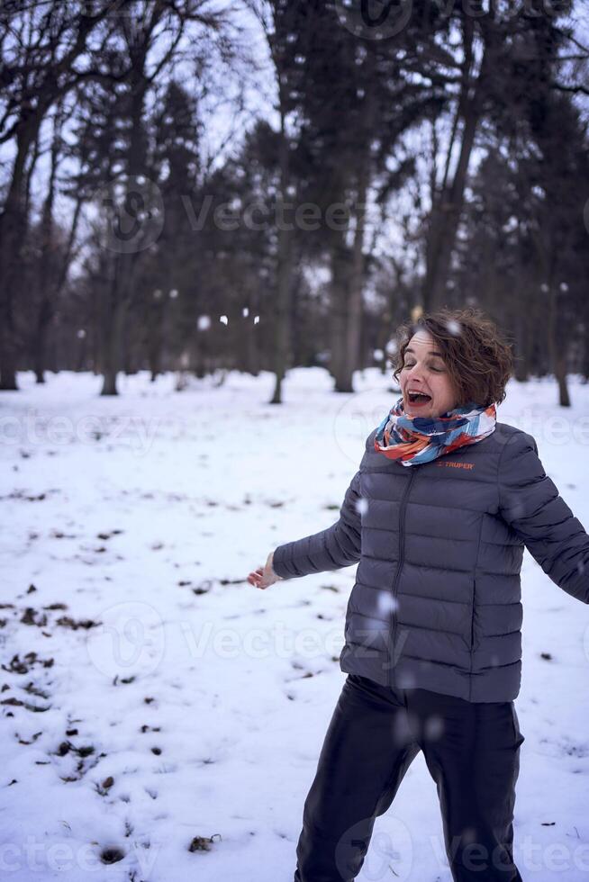 femme jouer avec neige dans forêt photo