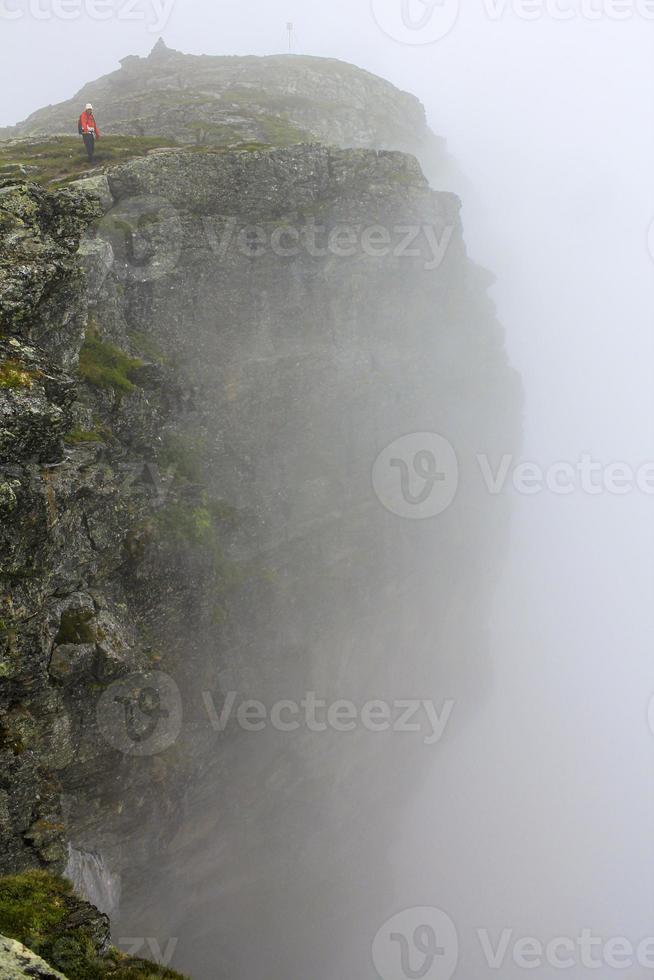 brouillard, nuages, rochers et falaises sur la montagne veslehodn veslehorn, norvège. photo