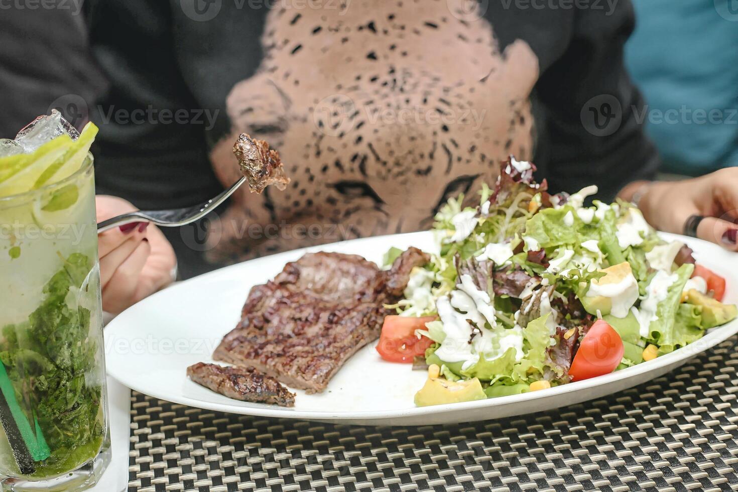 la personne séance à table avec assiette de nourriture photo