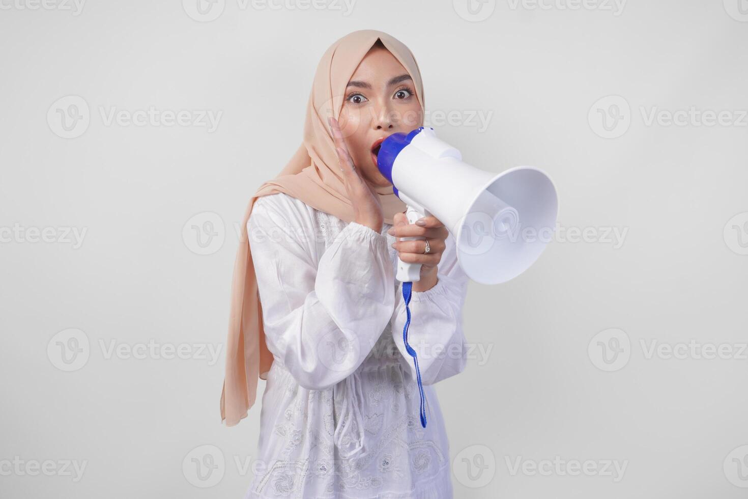 fou de joie asiatique femme portant hijab et blanc robe en criant à le mégaphone fabrication annonce, permanent plus de isolé blanc Contexte photo